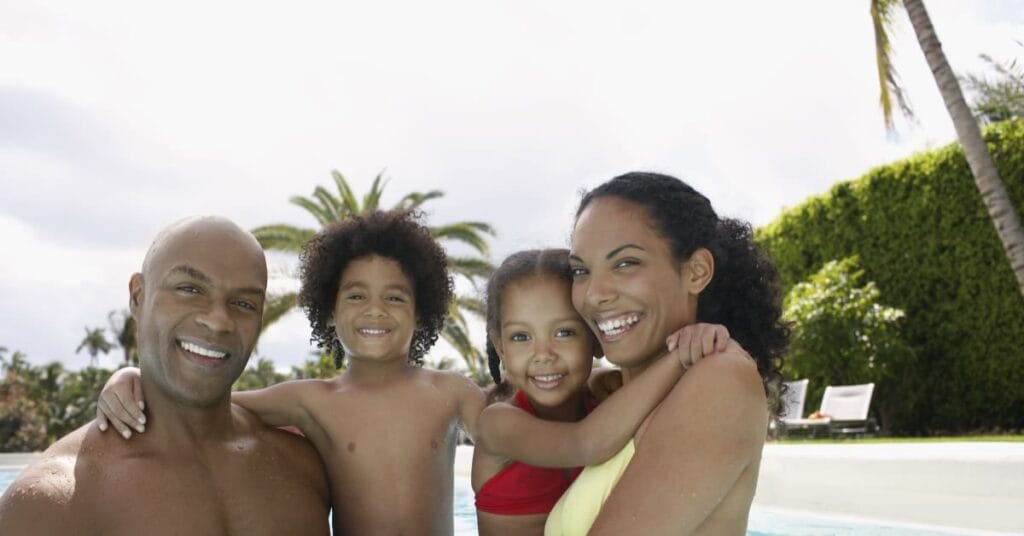 Couple swimming in pool with kids