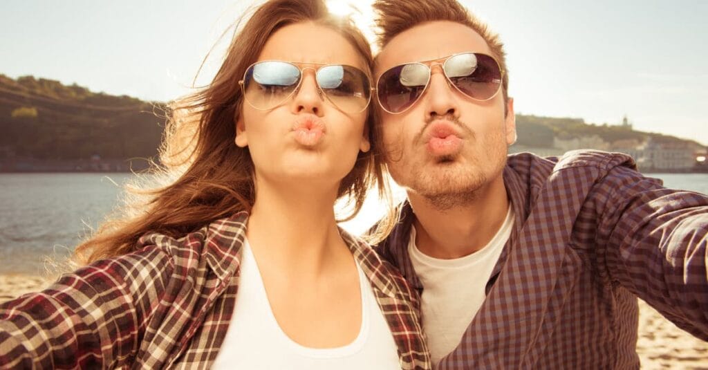 couple taking selfie behind landscape