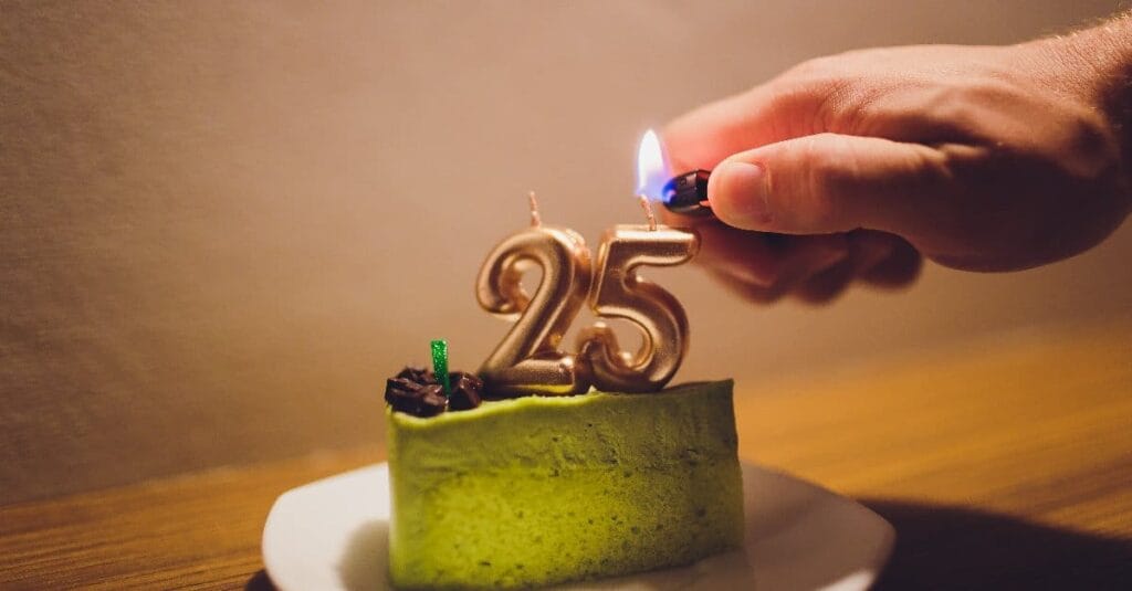 a man lighting candles on 25th birthday cake